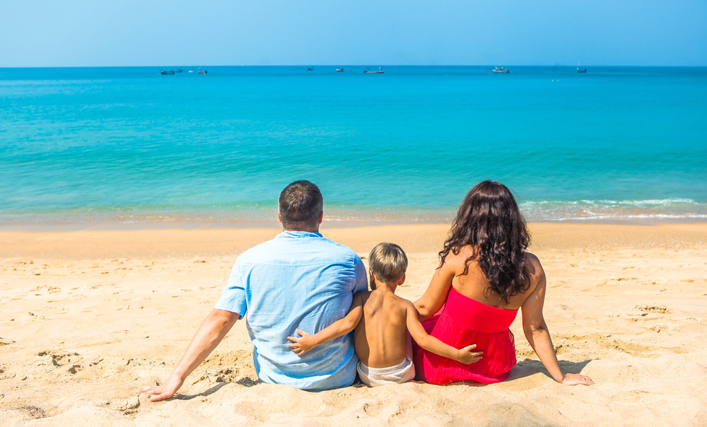 Como viajar com as crianças no calor sem estresse? 3 casal praia crianca